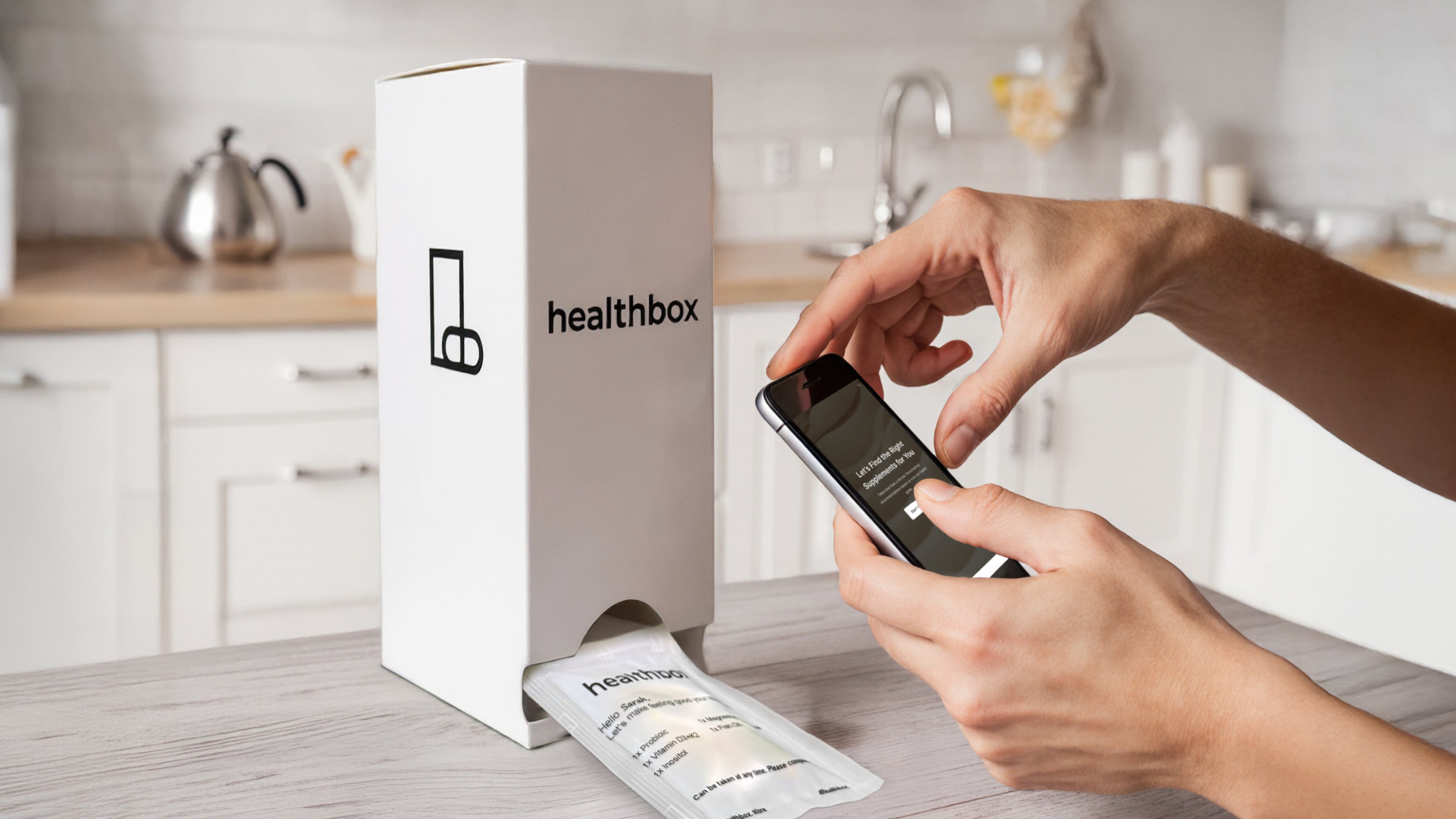 Person using a smartphone with a Healthbox product in a kitchen setting