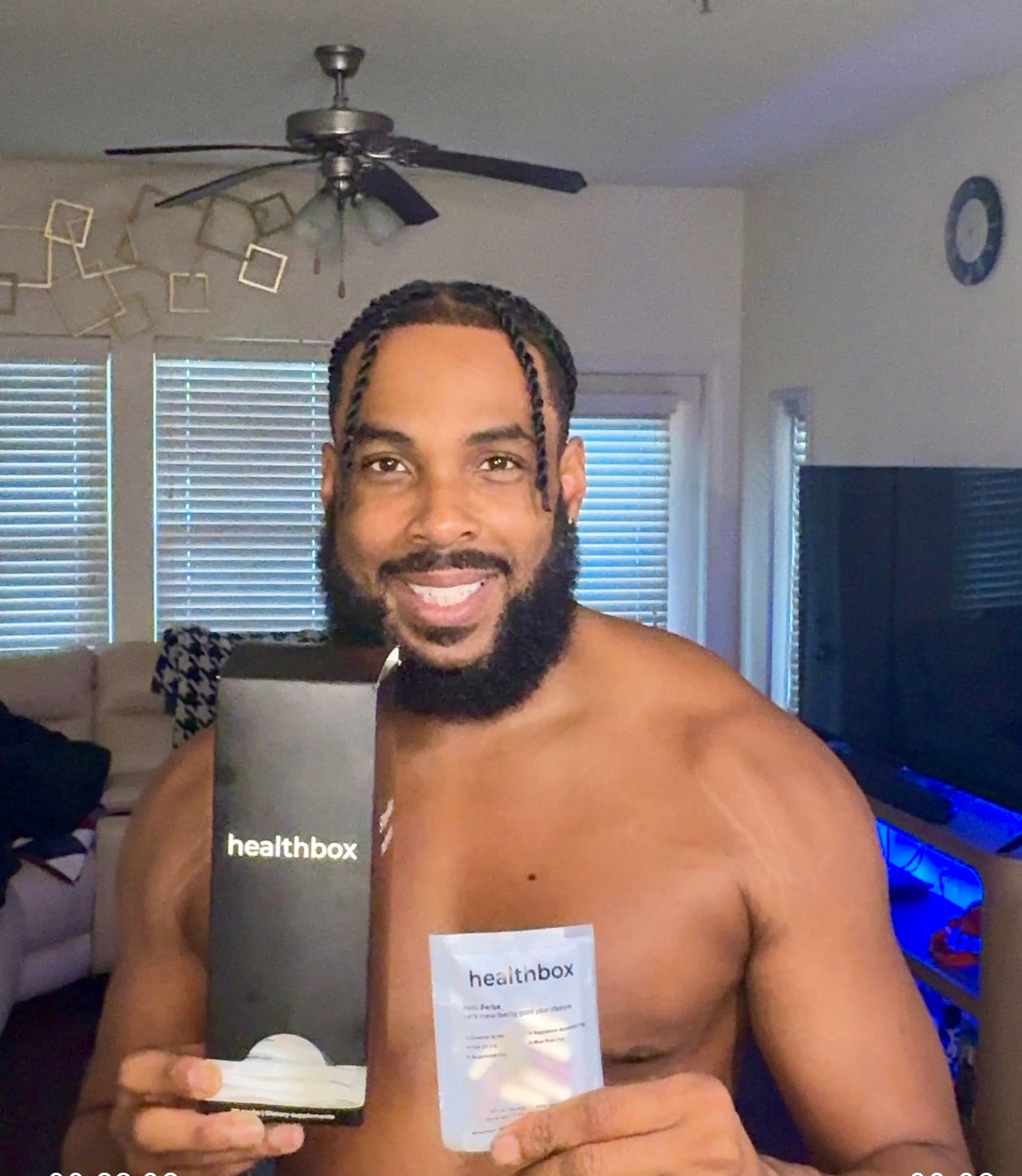 Man holding a Healthbox product in a living room setting