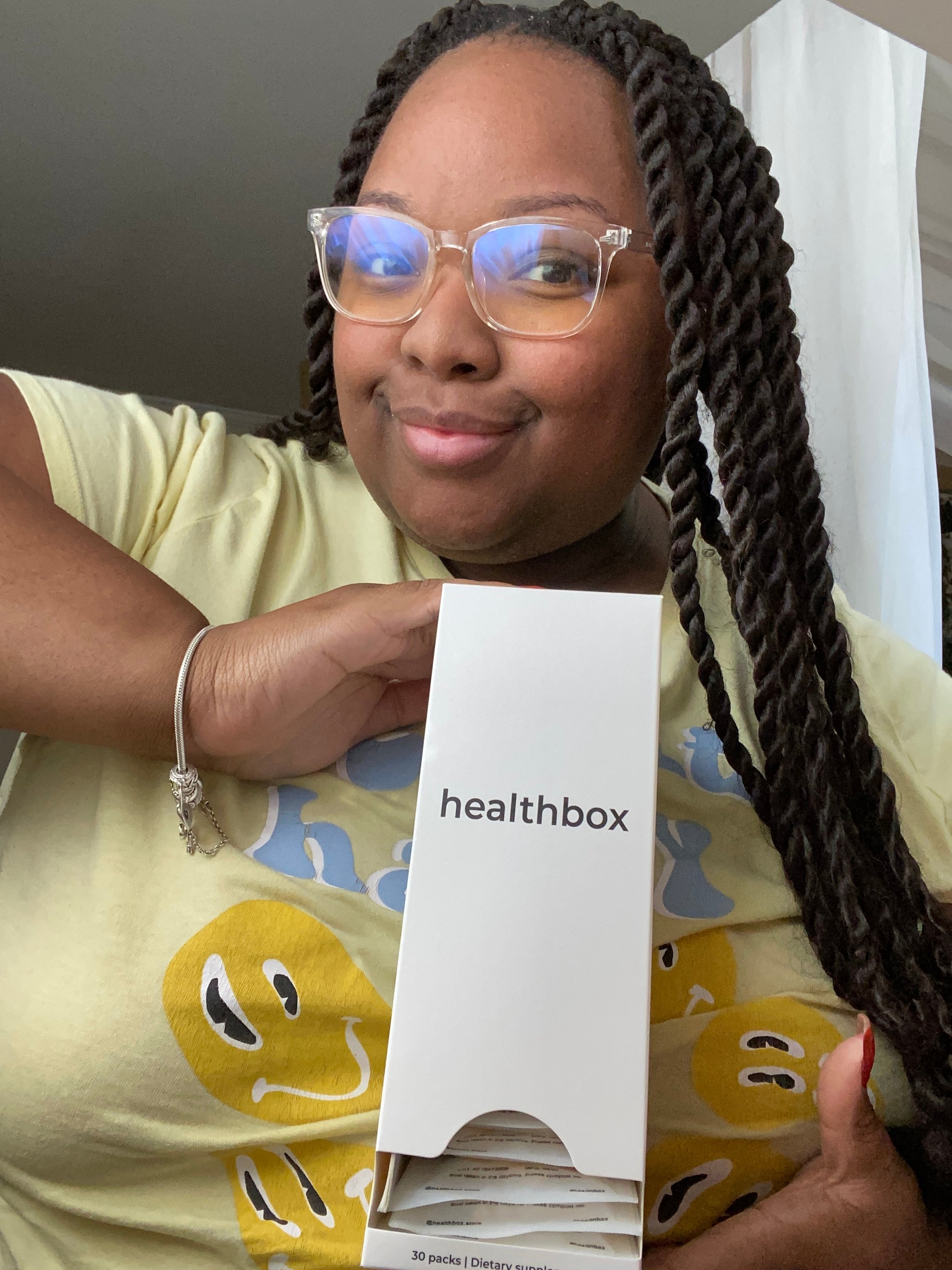 Person holding a Healthbox product box with a neutral background